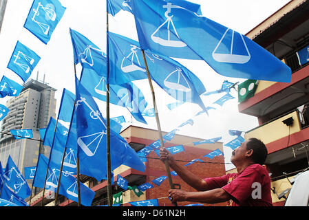 Petaling Jaya, Selangor, Malaisie. 11 avril 2013. 11 avril 2013 - Kuala Lumpur, KUALA LUMPUR, MALAISIE - un travailleur ajuste le Barisan Nasional drapeau dans Kuala Lumpur, Malaisie. La coalition Barisan Nasional ou la Malaisie est avant décision fédérale du parti politique comme il s'agit d'indépendance le 31 août, 1957. La Malaisie 13e élections générales auront lieu le 5 mai 2013, à la suite de la dissolution du Parlement annoncé par le Premier Ministre, Najib Razak, le 3 avril 2013. (Crédit : Crédit : Image/ZUMAPRESS.com/Alamy Sellehuddin Kamal Live News) Banque D'Images