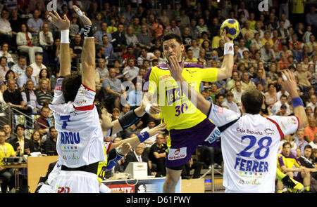 Berlin's Alexander Petersson (M) passe à tirer du net à Leon Alvaro Ferrer Vecilla (R) et Carou Marcel Gonzalo (L) lors de la Ligue des Champions hommes deuxième quart de finale match aller entre Berlin et renards Ademar Leon à Max-Schmelinghalle à Berlin, Allemagne, 29 avril 2012. Photo : WOLFGANG KUMM Banque D'Images