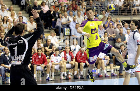 Berlin's Alexander Petersson (C) passe à tirez contre Leon's gardien Alamo Yeste (L) lors de la Ligue des Champions hommes deuxième quart de finale match aller entre Berlin et renards Ademar Leon à Max-Schmelinghalle à Berlin, Allemagne, 29 avril 2012. Photo : WOLFGANG KUMM Banque D'Images