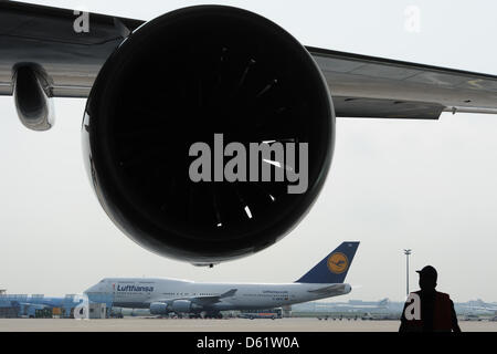 Un Boeing 747-400 de Lufthansa AG est représentée derrière un moteur d'un nouveau Boeing 747-8 à l'aéroport de Francfort à Francfort-sur-Main, Allemagne, 02 mai 2012. Lufthansa est la première compagnie aérienne dans le monde entier pour ajouter le nouveau Boeing pour sa flotte de passager. Le nouveau 747-8 est de 5 mètres de plus que le modèle précédent 747-400 et est censé être beaucoup plus silencieux et plus efficace. Photo : ARNE Banque D'Images