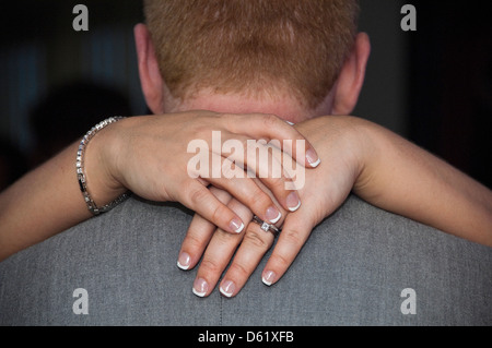 L'horizontale close up of a woman's hands autour du cou d'un homme au cours d'une danse. Banque D'Images