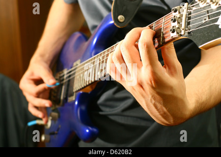 L'homme jouer des solos de guitare bleu Banque D'Images