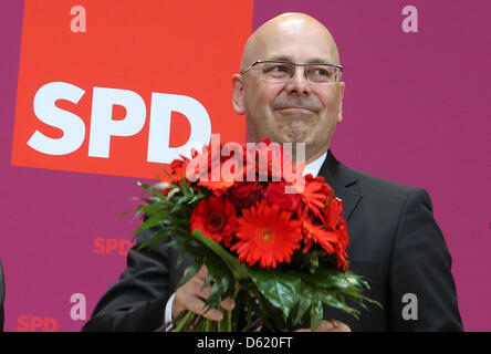 Schleswig-Holstein candidat de tête les sociaux-démocrates (SPD), Torsten Albig, reçoit des fleurs au cours d'une réunion des parties à la maison Willy Brandt à Berlin, Allemagne, 07 mai 2012. Chef du SPD, Sigmar Gabriel, estime pour former un gouvernement avec les Verts et la Fédération des électeurs du Schleswig du Sud (SSW). Photo : WOLFGANG KUMM Banque D'Images