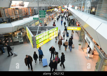 Les voyageurs à pied passé boutiques à l'aéroport de Tegel à Berlin, Allemagne, 09 mai 2012. Le nouvel aéroport de Berlin-Brandeburg (BER) dans Berlin-Schienefeldt n'ouvre pas le 03 juin comme prévu. Son entrée en service sera retardé d'au moins deux mois jusqu'en août 2012. L'aéroport de Tegel et Schoenefeld va maintenant rester ouvert plus longtemps que prévu pour qu'aucun vol doivent être annulées au cours de l'été Banque D'Images