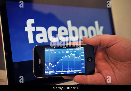 ILLUSTRATION - An illustrated photo montre un Apple iPhone4s'afficher l'app Bourse en face de l'écran d'un ordinateur avec le logo de Facebook à Stuttgart, Allemagne, 08 mai 2012. Peu avant l'entrée en bourse Facebook a concédé une faiblesse dans son plan d'affaires : Les utilisateurs qui accèdent à Facebook via les smartphones ou tablettes génèrent peu de revenus. Plus de la moitié de Facebook. Banque D'Images