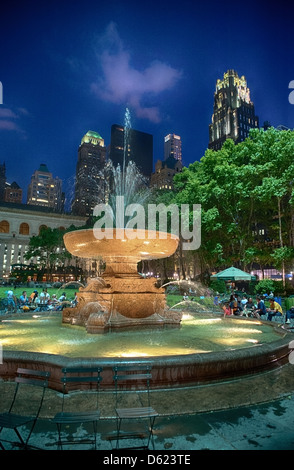 La fontaine de Bryant Park New York City flanquée d'immeubles à appartements dans la nuit Banque D'Images