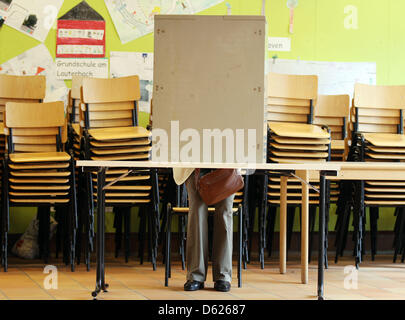 Une femme assise dans l'isoloir dans un bureau de vote de Bonn, Allemagne, 13 mai 2012. Autour de 13 millions d'électeurs en Rhénanie du Nord-Westphalie sont appelés à élire un nouveau parlement de l'Etat. Photo : Oliver Berg Banque D'Images