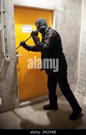 ILLUSTRATION - Une photo montre un homme faisant levier ouvrir une porte avec un pied de biche à Berlin, Allemagne, 20 avril 2012. Les statistiques de la criminalité 2011 pour Berlin ont été publiés le 23 avril 2012. Le nombre d'infractions enregistrées a considérablement augmenté pour la première fois depuis des années. Photo : Robert Schlesinger Banque D'Images