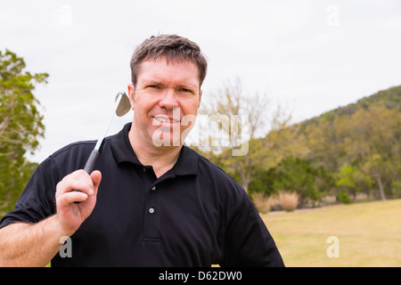 Caucasianman d'âge moyen de 46 ans avec le fer sur un terrain de golf club Banque D'Images