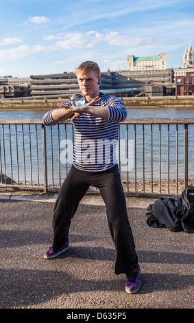 Un artiste de la rue qui jongle avec une orbe de cristal sur la promenade de la Tamise, South Bank, Londres, Angleterre, Royaume-Uni. Banque D'Images