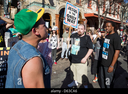 Les jeunes hommes homosexuels hispaniques soutient avec un anti-gay religieux homme de race blanche au cours d'un festival en plein air à Austin, Texas Banque D'Images