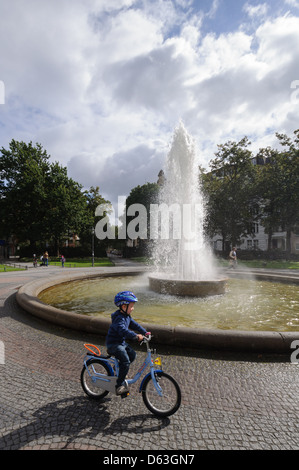 Enfant sur un vélo à Viktoria Luise Platz, Berlin - Allemagne. Banque D'Images