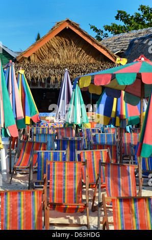 Locations de chaises longues et parasols sur la plage de sable de l'île tropicale de la Thaïlande Banque D'Images