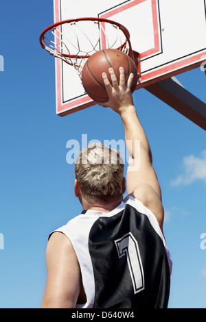 Basket-ball joueur lance la balle dans le panier Banque D'Images