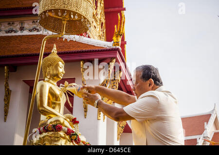 Bangkok, Thaïlande. 12 avril 2013. Gouverneur de Bangkok Sukhumbhand Paribatra baigne le Phra Buddha Sihing en huiles parfumées pendant le début de Bangkok Songkran observances. Le Phra Buddha Sihing vénéré, une statue de Bouddha, s'effectue par camion à travers les rues de Bangkok afin que les gens peuvent faire des offrandes et se baigner dans les huiles parfumées. Songkran est célébré en Thaïlande comme le traditionnel jour de l'an, du 13 au 16 avril.Credit : ZUMA Press, Inc. / Alamy Live News Banque D'Images