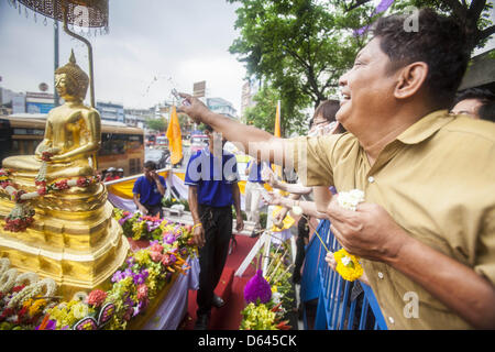 Bangkok, Thaïlande. 12 avril 2013. Les thaïs saupoudrer les huiles parfumées sur le Phra Buddha Sihing alors que c'est ont défilé dans les rues de Bangkok sur la première journée d'Songrkran. Le Phra Buddha Sihing vénéré, une statue de Bouddha, s'effectue par camion à travers les rues de Bangkok afin que les gens peuvent faire des offrandes et se baigner dans les huiles parfumées. Songkran est célébré en Thaïlande comme le traditionnel jour de l'an, du 13 au 16 avril.Credit : ZUMA Press, Inc. / Alamy Live News Banque D'Images