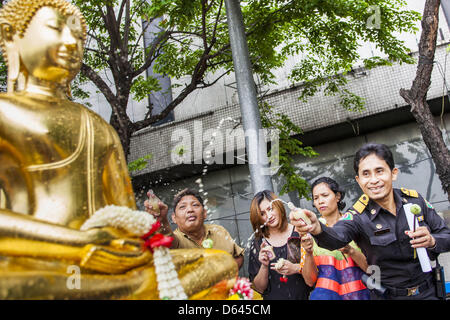 Bangkok, Thaïlande. 12 avril 2013. Les thaïs saupoudrer les huiles parfumées sur le Phra Buddha Sihing alors que c'est ont défilé dans les rues de Bangkok sur la première journée d'Songrkran. Le Phra Buddha Sihing vénéré, une statue de Bouddha, s'effectue par camion à travers les rues de Bangkok afin que les gens peuvent faire des offrandes et se baigner dans les huiles parfumées. Songkran est célébré en Thaïlande comme le traditionnel jour de l'an, du 13 au 16 avril.Credit : ZUMA Press, Inc. / Alamy Live News Banque D'Images