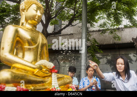 Bangkok, Thaïlande. 12 avril 2013. Les thaïs saupoudrer les huiles parfumées sur le Phra Buddha Sihing alors que c'est ont défilé dans les rues de Bangkok sur la première journée d'Songrkran. Le Phra Buddha Sihing vénéré, une statue de Bouddha, s'effectue par camion à travers les rues de Bangkok afin que les gens peuvent faire des offrandes et se baigner dans les huiles parfumées. Songkran est célébré en Thaïlande comme le traditionnel jour de l'an, du 13 au 16 avril.Credit : ZUMA Press, Inc. / Alamy Live News Banque D'Images