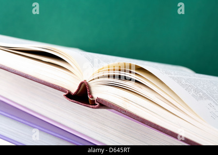 Pile de manuels colorés avec livre ouvert sur sa partie supérieure Banque D'Images