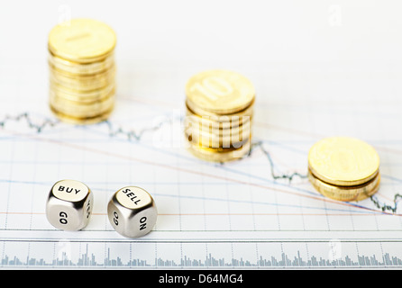 Les mots avec des cubes dés vendre acheter et de pièces sur la pile d'or tableau financier baisse. Selective focus Banque D'Images