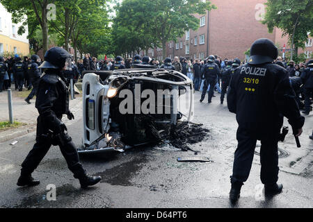 Des agents de police devant une voiture incendiée au cours d'un blocus de manifestants contre une marche de l'extrême droite à la "Journée de l'avenir" allemand à Hambourg, Allemagne, 02 juin 2012. Plusieurs milliers manifestent contre le rassemblement néo-nazi. Photo : CHRISTIAN CHARISIUS Banque D'Images