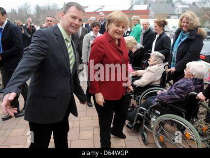 Melle-Wellingholzhausen, Allemagne. 12 avril 2013. La chancelière allemande Angela Merkel (C) accueille les personnes âgées assis dans un fauteuil roulant avec le responsable de la haute rue centre Konrad Johannes Wolters (L) Melle-Wellingholzhausen, Allemagne, 12 avril 2013. Merkel a recueilli des informations sur le concept de centres de retraite, dans laquelle les personnes âgées peuvent vivre ensemble dans des communautés. Photo : Ingo Wagner/dpa/Alamy Live News Banque D'Images