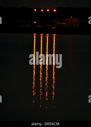 Cette image montre le Danube la nuit, avec des lumières artificielles réfléchissant sur l'eau calme. La scène capture l'interaction sereine et belle entre la rivière et les lumières de la ville, offrant une vue paisible mais dynamique de la voie navigable la nuit. Banque D'Images