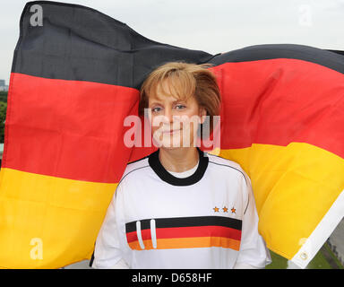 Une figure de cire de la chancelière allemande Angela Merkel en allemand de l'équipe de soccer jersey est représenté à l'extérieur de Madame Tussauds en face de la porte de Brandebourg à Berlin, Allemagne, 14 juin 2012. La Merkel figure fera partie de l'exposition pour le moment de l'UEFA Euro 2012. Photo : JENS KALAENE Banque D'Images