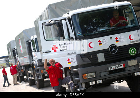 Aides de la Croix-Rouge allemande DRK préparer le transport de trois véhicules d'urgence de l'aéroport de Schoenefeld en Syrie en Schönefeld, Allemagne, 15 juin 2012. Les véhicules sont une partie d'un projet plus vaste visant à aider la Libye et de l'appui de la logistique de la Croissant Rouge. De cette façon, les biens et l'aide médicale peut être portée à la population de la Syrie plus rapidement. La DRK a été active en Syrie sinc Banque D'Images