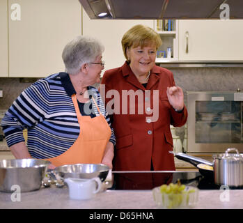 Melle, Allemagne. 12 avril 2013. La chancelière allemande Angela Merkel parle d'une personne âgée dans une cuisine au cours de sa visite d'une maison de retraite à Melle, Allemagne, 12 avril 2013. Photo : MARTIN MEISSNER/dpa/Alamy Live News Banque D'Images