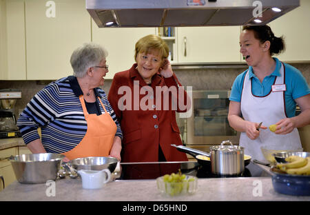 Melle, Allemagne. 12 avril 2013. La chancelière allemande, Angela Merkel, à l'écoute des résidents et des soignants dans une cuisine au cours de sa visite d'une maison de retraite à Melle, Allemagne, 12 avril 2013. Photo : MARTIN MEISSNER/dpa/Alamy Live News Banque D'Images