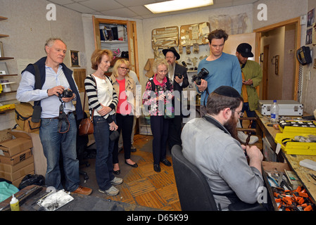 Un groupe touristique visite un lieu où teffilin (phylactères) sont réalisés dans Crown Heights, Brooklyn, New York Banque D'Images
