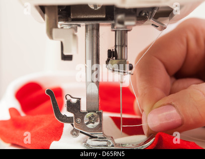 Un égout enfiler une aiguille dans la machine à coudre. Banque D'Images