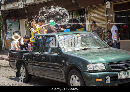 Bangkok, Thaïlande. 13 avril, 2013. Les enfants thaïlandais dans l'arrière d'une camionnette jeter l'eau sur les touristes sur Soi Nana, au large de la route Sukhumvit de Bangkok. Songkran est célébré en Thaïlande comme le traditionnel jour de l'An du 13 au 16 avril. La date du festival a été initialement défini par calcul astrologique, mais c'est maintenant corrigé. Si les jours tombent un week-end, les jours manqués sont prises sur la semaine qui suit immédiatement. Alamy. Banque D'Images