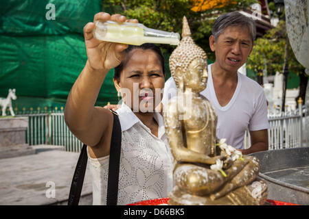 Bangkok, Thaïlande. 13 avril, 2013. Un couple se baigne une statue du Bouddha aux huiles parfumées sur Songkran à Bangkok. Songkran est le Nouvel An Thaï traditionnel Festival. C'est tenue du 13 au 16 avril. De nombreux Thaïlandais marquer la maison de vacances en allant dans les temples et les décisions en donnant du mérite de l'aumône aux moines supplémentaires ou plus des prières. Ils ont également mark Songkran avec de l'eau joyeuse se bat. Songkran est une fête nationale depuis 1940, lorsque la Thaïlande a présenté la première journée de l'année au 1 janvier. (Crédit Image : Crédit : Jack Kurtz/ZUMAPRESS.com/Alamy Live News) Banque D'Images