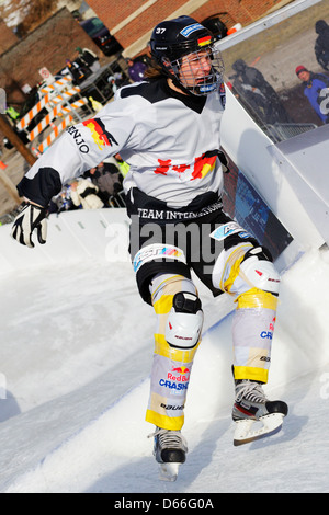 Un concurrent dans la compétition Red Bull Crashed Ice skates en bas de la voie au cours de la concurrence au Carnaval de Saint Paul. Banque D'Images