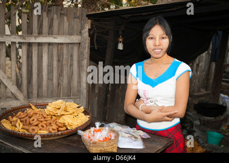 Jeune femme vendant de la nourriture, j'Kyi village, Mandalay, Myanmar (Birmanie), Banque D'Images