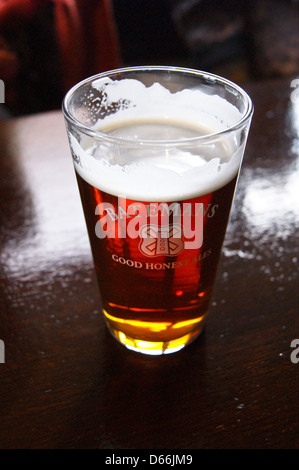 Une pinte de verre imprimé sur un amer Batemans pub bar boissons verres de table Banque D'Images