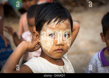 Jeune enfant portant thanaka sur son visage, j'Kyi village, Mandalay, Myanmar (Birmanie), Banque D'Images