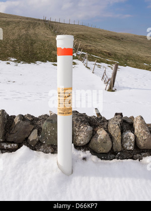 Position de marquage marqueur post pipeline souterrain de gaz dans la neige en campagne près de Snowdonia, Conwy dans le Nord du Pays de Galles, Royaume-Uni, Angleterre Banque D'Images