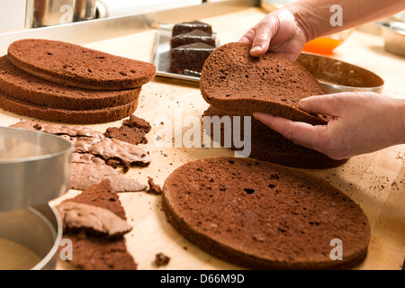 Gâteau au chocolat coupe Chef et empiler les couches Banque D'Images