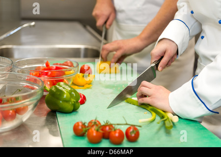 Close up de chefs couper des légumes dans la cuisine de l'hôtel Banque D'Images