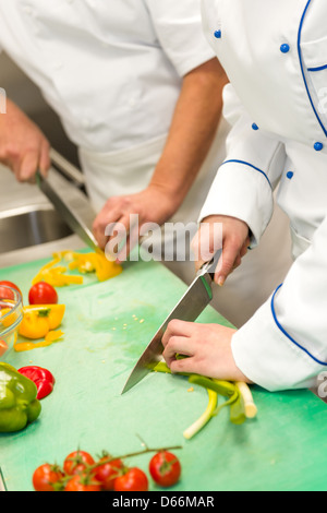 Close up de chefs couper des légumes dans la cuisine de l'hôtel Banque D'Images