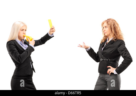 Woman in suit montrant une carte jaune et en soufflant un sifflet pour une collègue, isolé sur fond blanc Banque D'Images