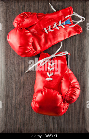 Gants de boxe rouge sur fond sombre en bois Banque D'Images