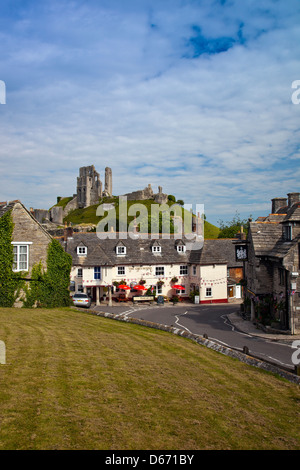 Ruines du château de Corfe tower au-dessus du pub et Greyhound Bankes Arms Hotel de Corfe Castle village, Dorset, England, UK Banque D'Images