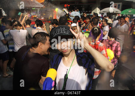 Bangkok, Thaïlande. 14 avril 2013. Songkran, une femme posant v les doigts à Silom road . Le festival du Nouvel An de la Thaïlande commence marquant le début de Nouvel An thaï, quand les gens célébrer de diverses façons, y compris les projections d'eau à l'autre pour la chance. Un Sahakorn Piti/Alamy Live News Banque D'Images