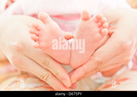 Pieds de bébé nouveau-né dans les mains des mères Banque D'Images