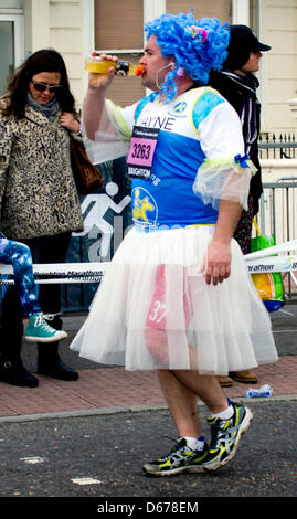 Brighton, UK. 14 avril, 2013. Habillé de fonctionner : un participant prend sur l'orange sur Marathon. Des milliers de personnes étaient alignés sur la route de 26 milles d'encourager les coureurs, beaucoup d'entre eux vêtus de costumes exotiques Banque D'Images