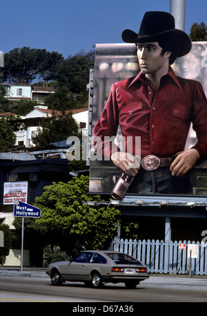 Un panneau mettant en vedette John Travolta promeut le film Urban Cowboy sur le Sunset Strip, à Hollywood, CA vers 1980 Banque D'Images